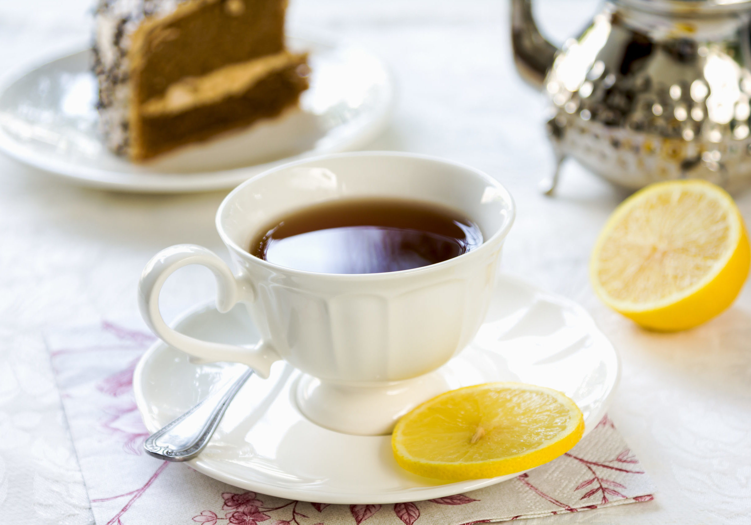 Balck tea with lemon by a tea pot
